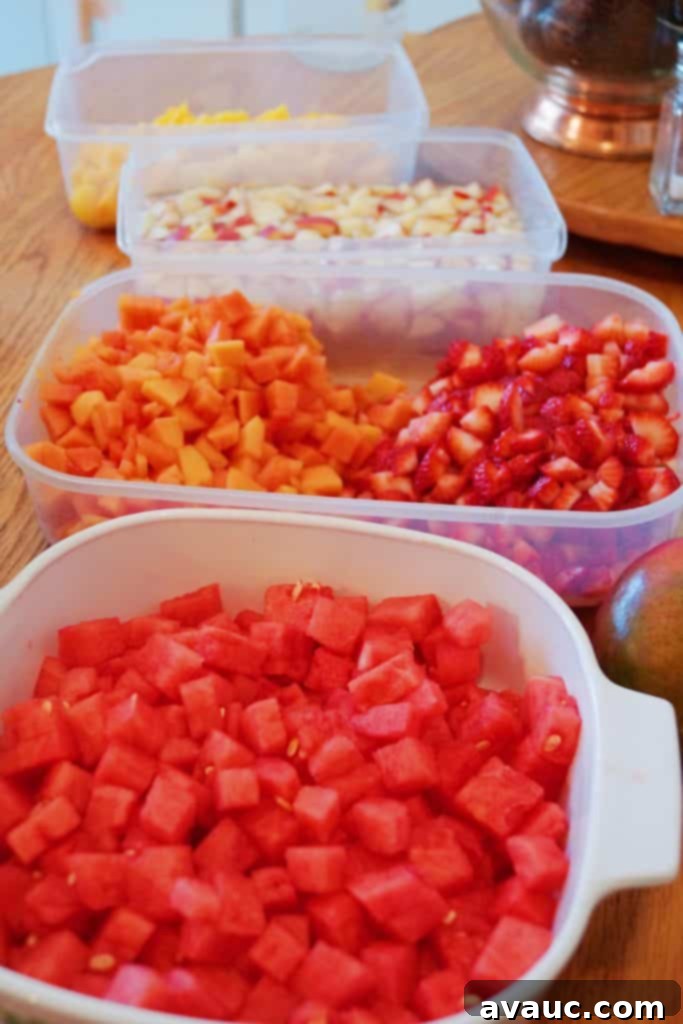 Close-up of a serving of Sweetened Condensed Milk Fruit Salad in a clear cup, showing the layers of fresh fruit and creamy white condensed milk, garnished with shredded coconut