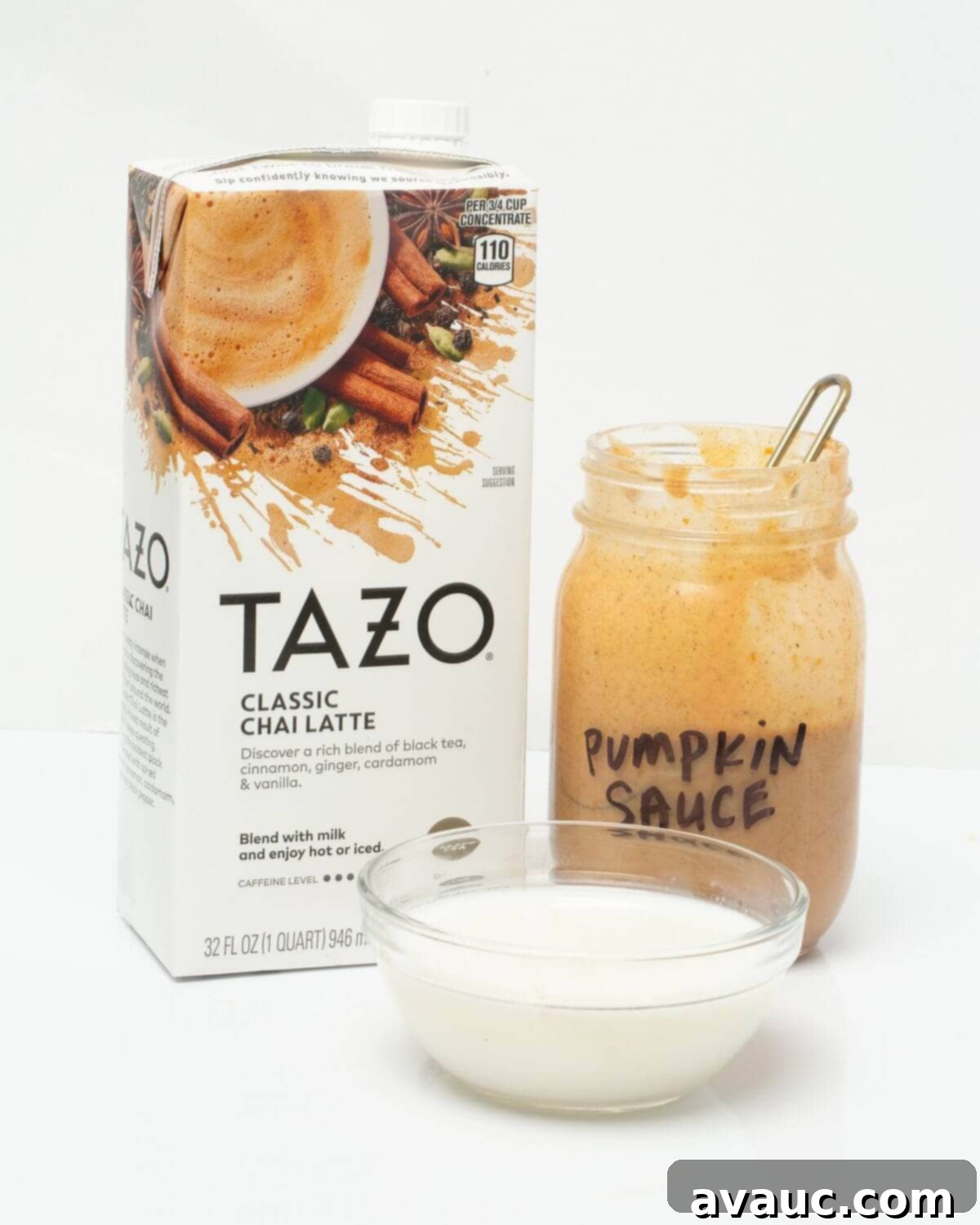 Autumn Pumpkin Chill Latte 4 Ingredients for Iced Pumpkin Cream Chai Latte laid out on a table: chai concentrate, milk, pumpkin puree, sweetened condensed milk, spices, and a mason jar.