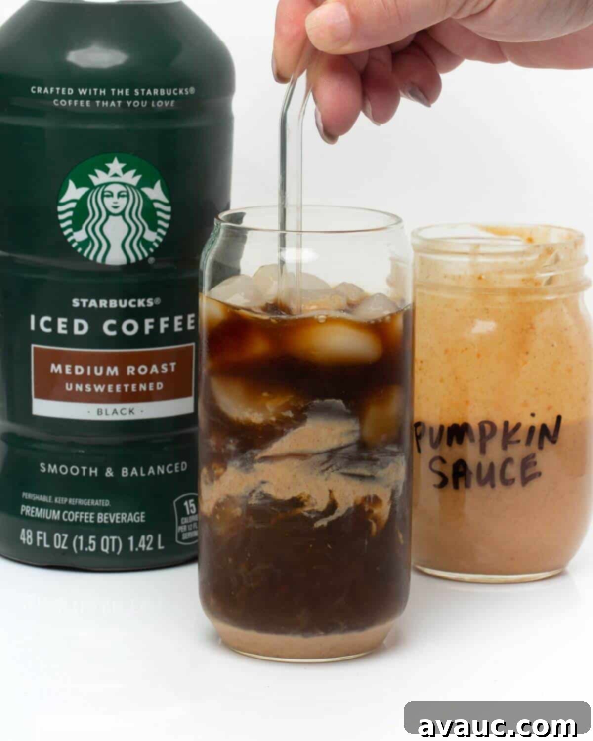 stirring pumpkin cream and cold brew in glass