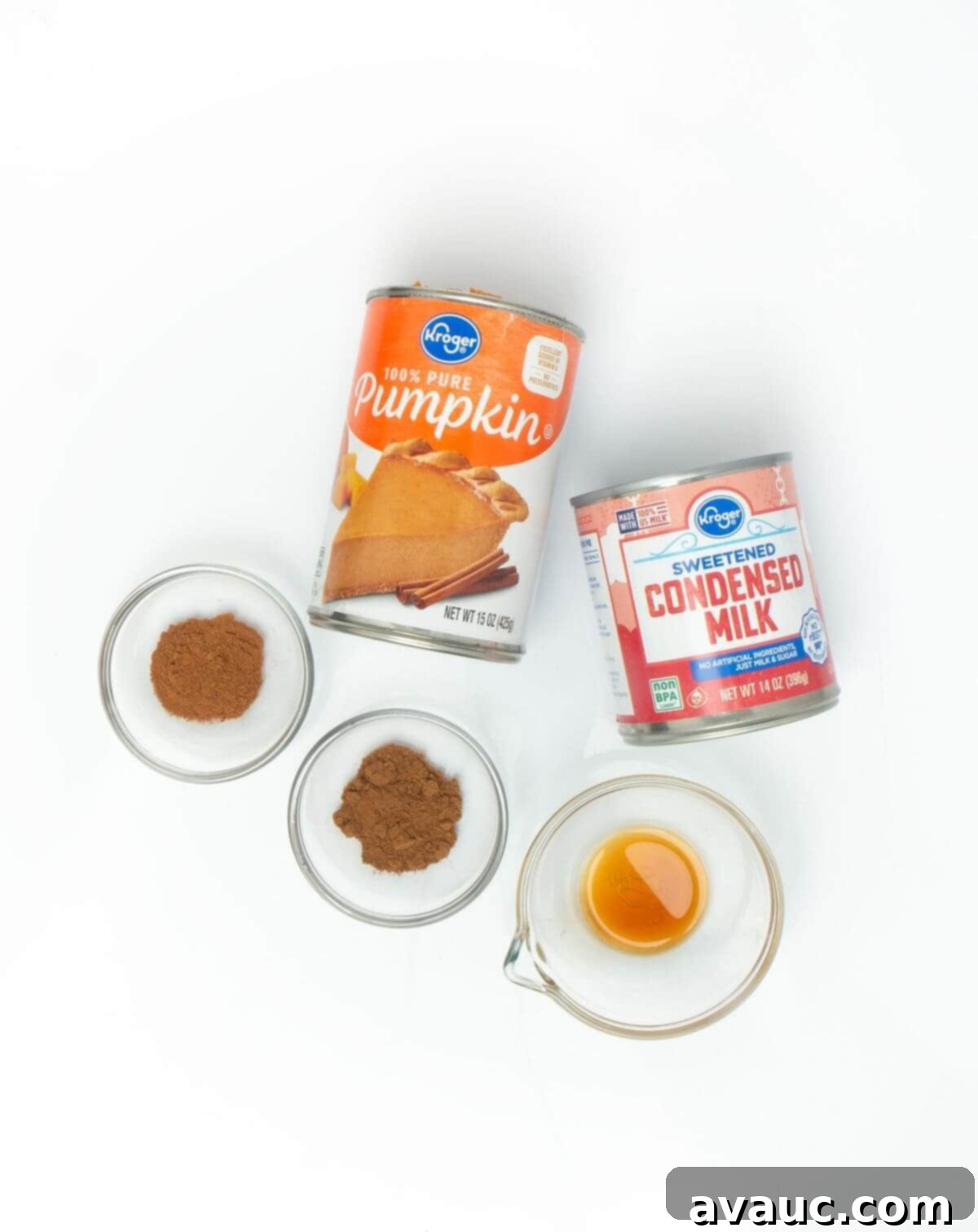 Handcrafted Pumpkin Spice Syrup 4 Individual ingredients for homemade pumpkin spice sauce laid out: canned pumpkin, sweetened condensed milk, cinnamon, pumpkin pie spice, and vanilla extract.