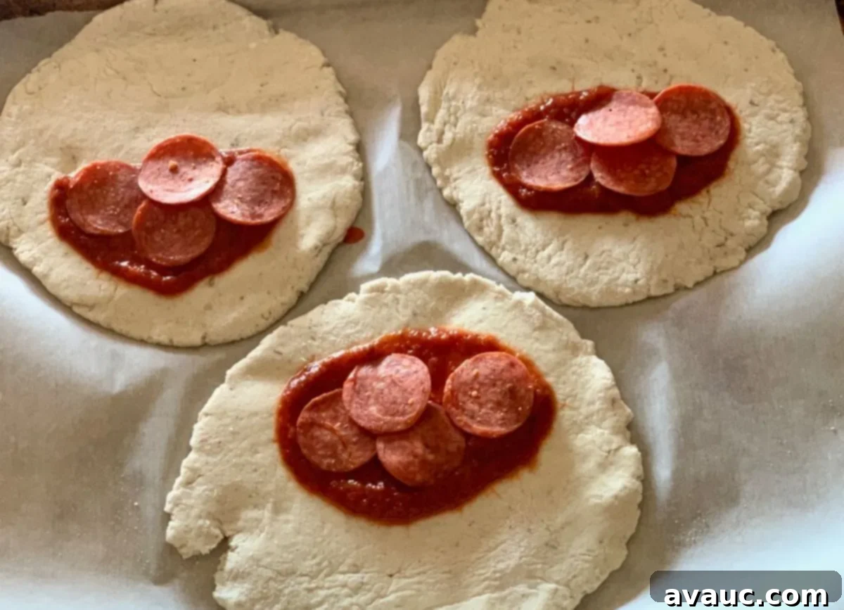 Crafting Your Own Calzone Delights 6 Gluten-free dough rounds topped with pizza sauce and pepperoni, ready to be folded into calzones.
