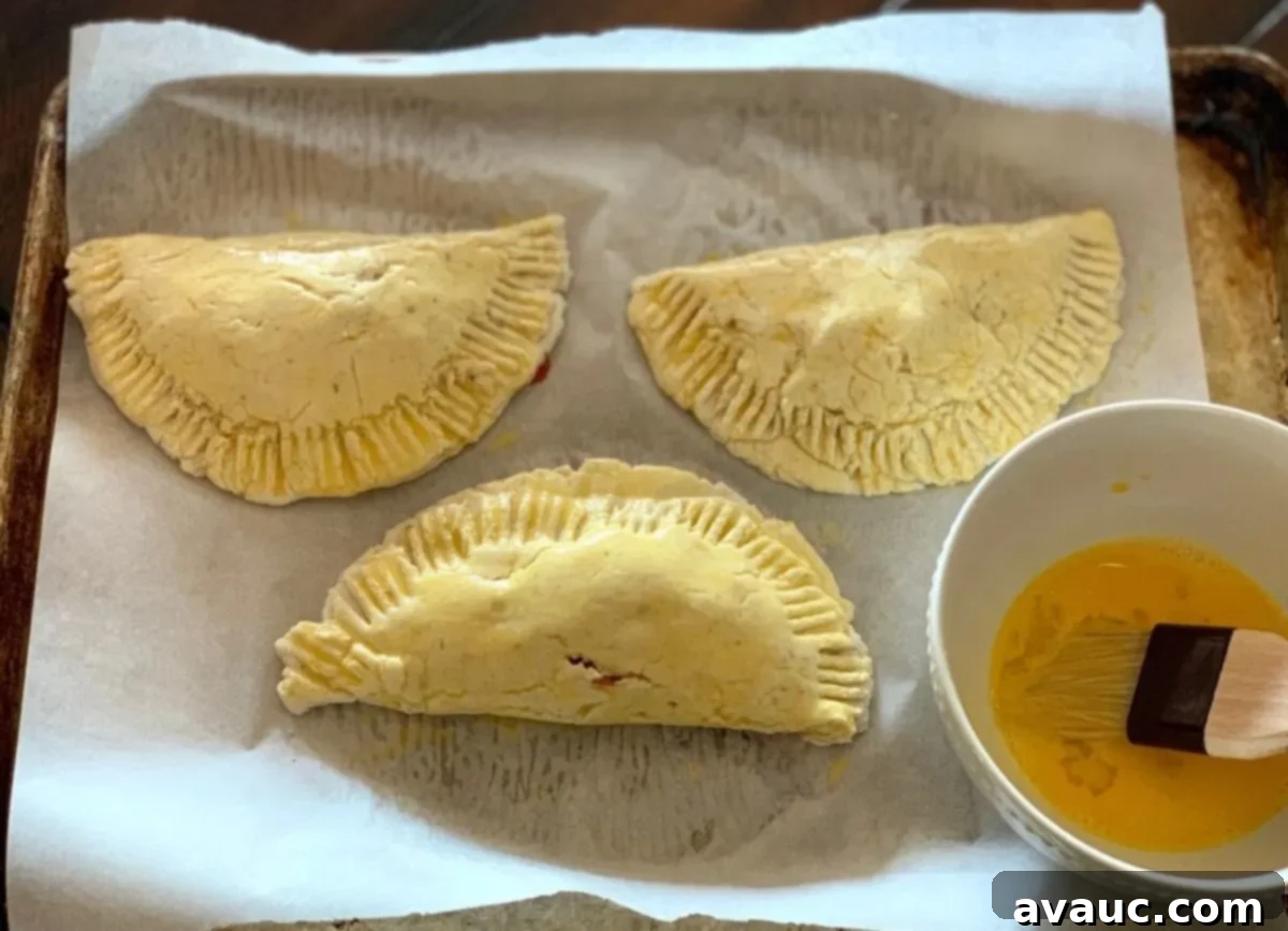 Crafting Your Own Calzone Delights 8 A close-up of gluten-free calzones being sealed with a fork, showing the fillings inside.