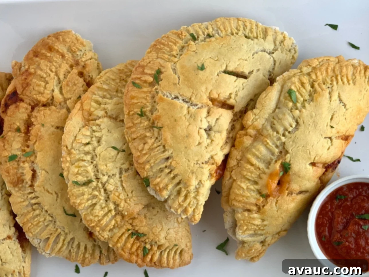 Crafting Your Own Calzone Delights 10 Warm, homemade calzones on a plate with pizza sauce.