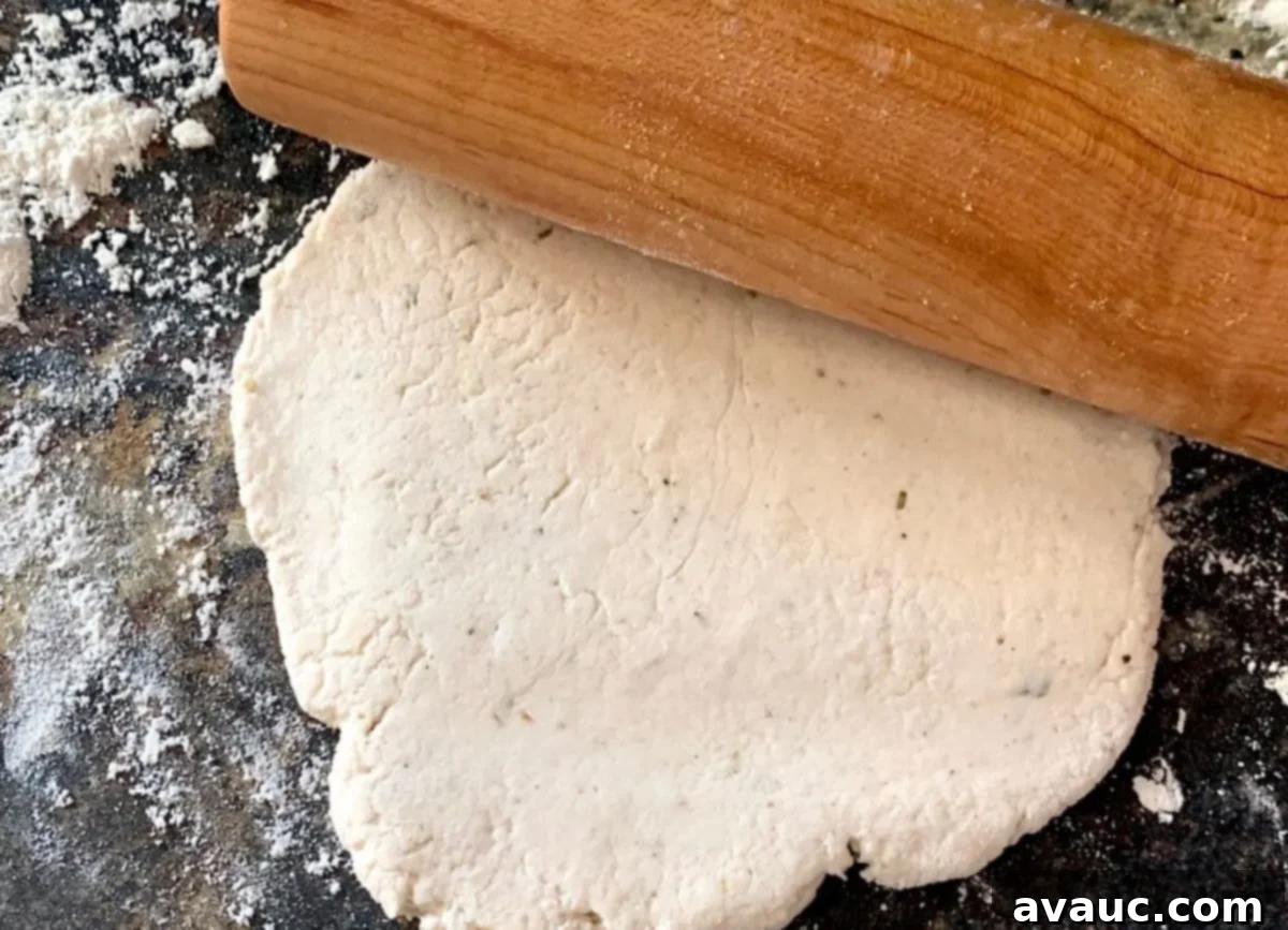 Crafting Your Own Calzone Delights 5 A rolling pin resting on a flattened circle of gluten-free dough, ready for calzone fillings.