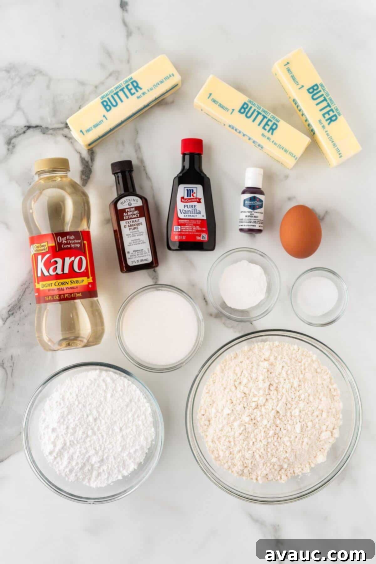 Collection of fresh baking ingredients for baseball sugar cookies, including butter, sugar, flour, and extracts.