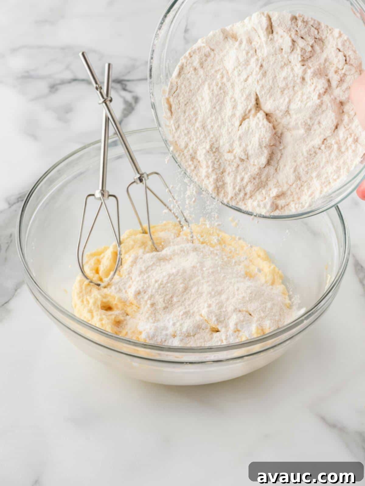 Spoon and level method demonstrating pouring flour into wet cookie dough ingredients