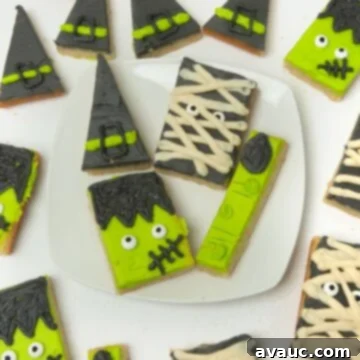 Close-up image of a decorated Halloween sugar cookie bar, showcasing the detailed artistry of the Frankenstein monster design, with vibrant green frosting, candy eyes, and black piped details.