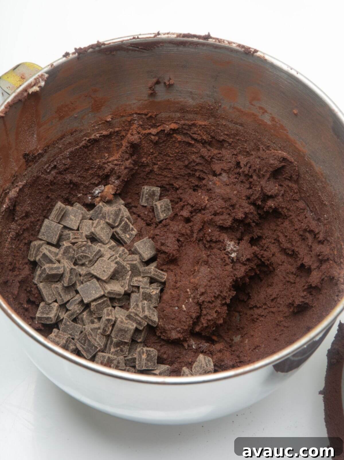 Dark chocolate cookie dough in mixing bowl with chocolate chunks visible.