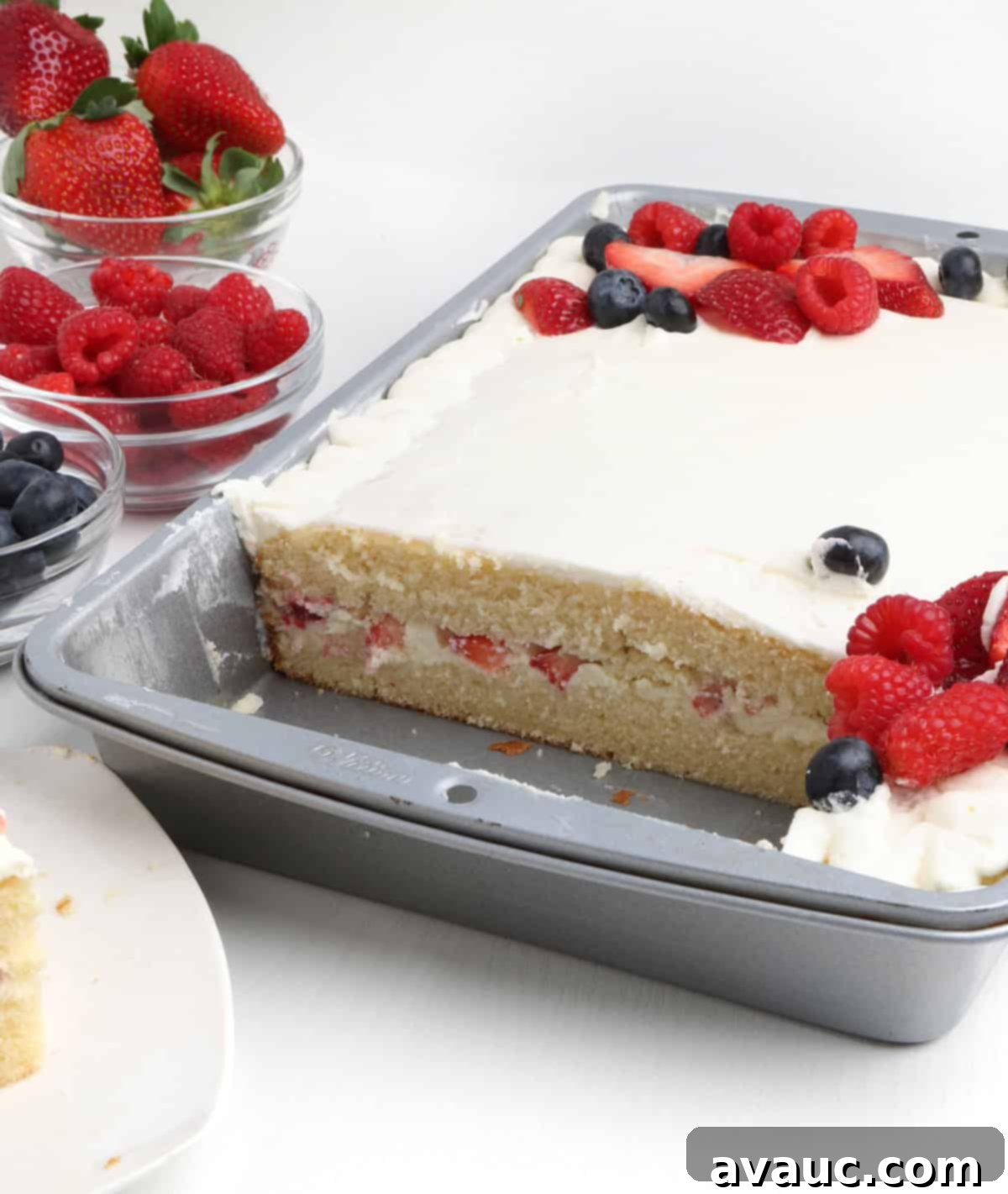 A beautifully layered white chantilly cake slice, showing the moist cake, creamy filling, and berries between layers
