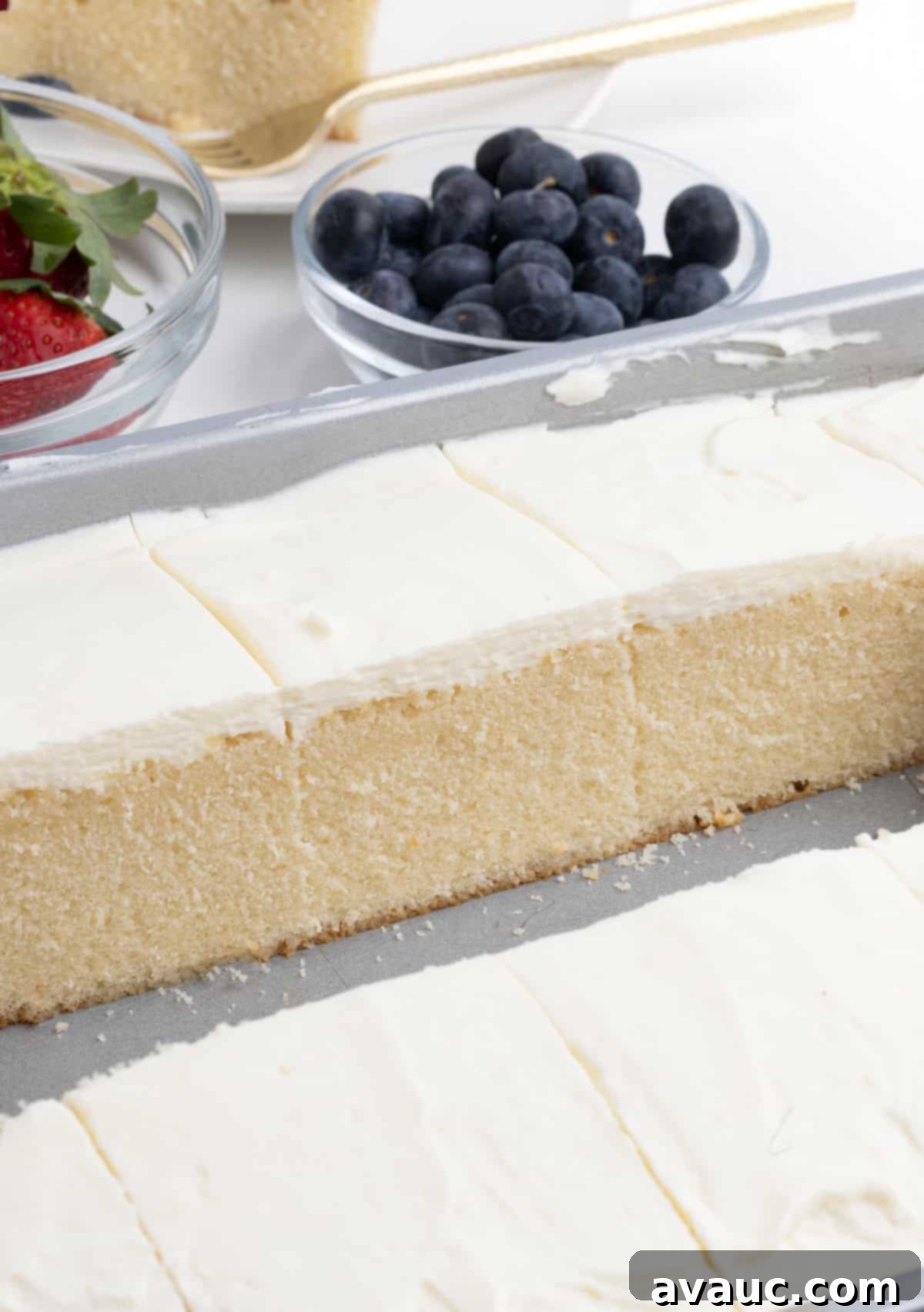 Close-up of a slice of white berry chantilly cake with light, creamy frosting and fresh berries