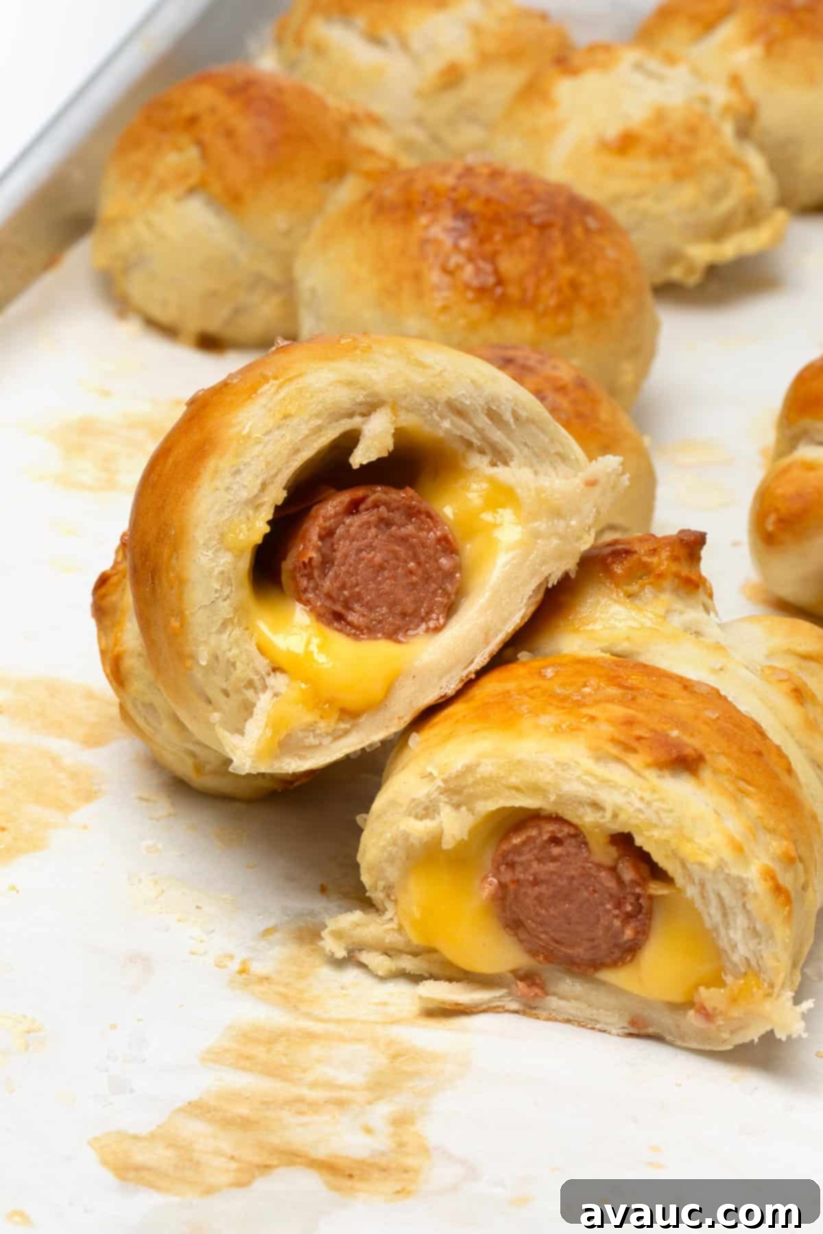 Pretzel Hot Dogs in a Flash 3 A freshly cut soft pretzel hot dog, revealing the juicy hot dog and melted cheddar cheese inside.