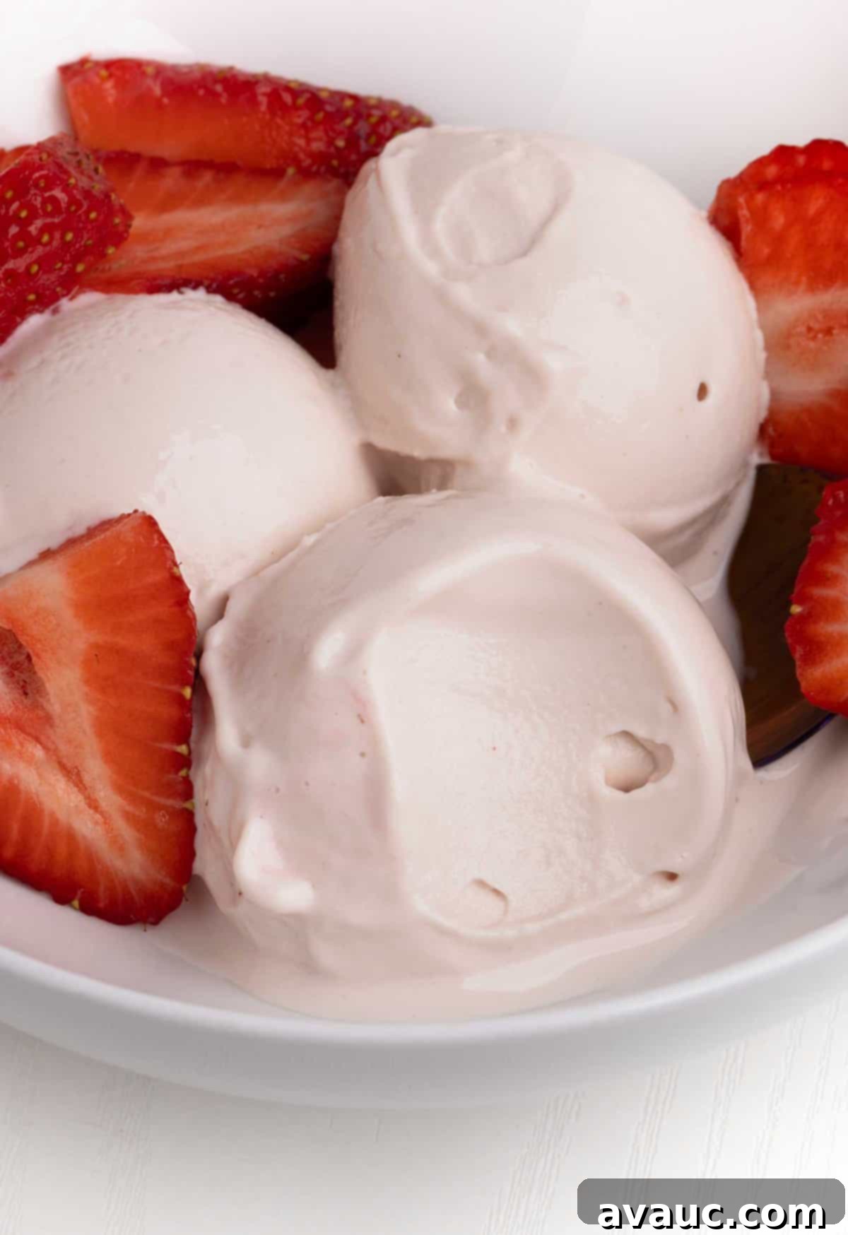 Ninja Creami Strawberry Protein Frozen Yogurt 2 Scoops of vibrant Ninja Creami strawberry protein frozen yogurt in a bowl, garnished with fresh strawberries