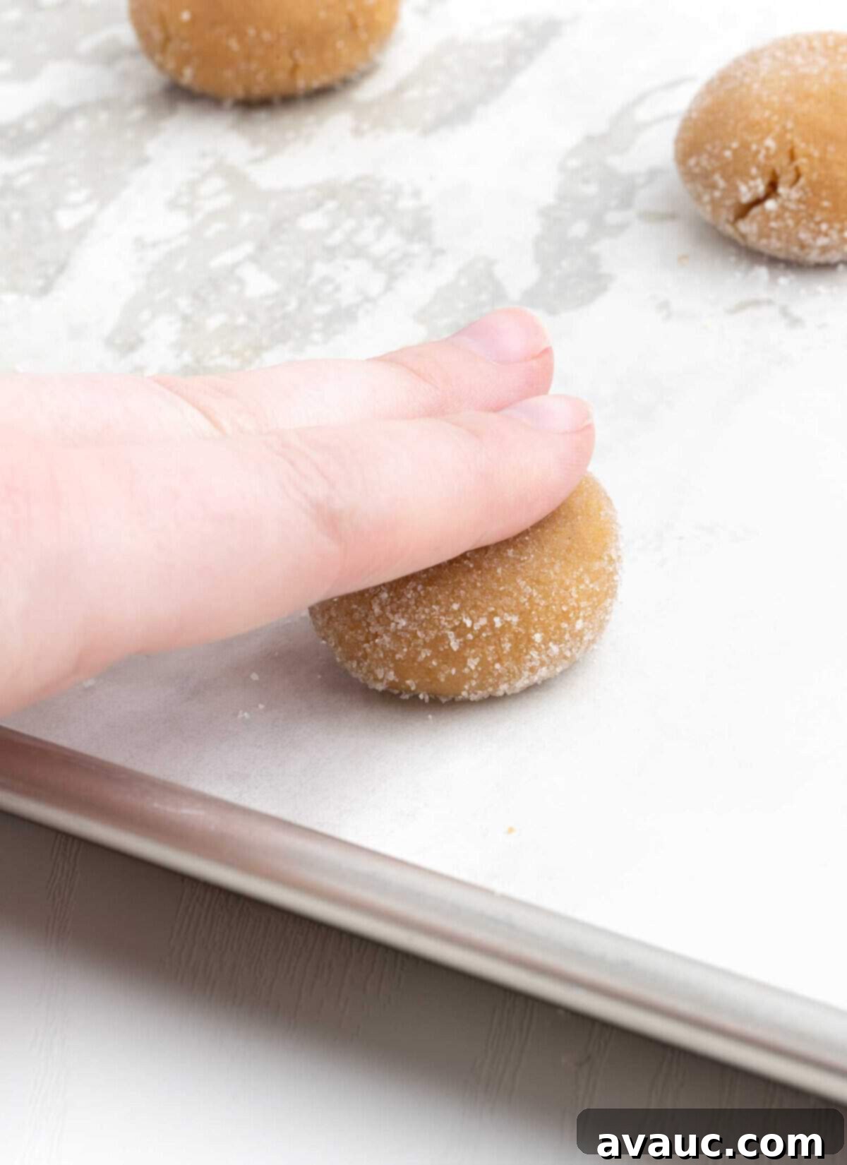 Peanut Butter Kiss Cookies 7 hand pressing down on peanut butter cookie dough ball