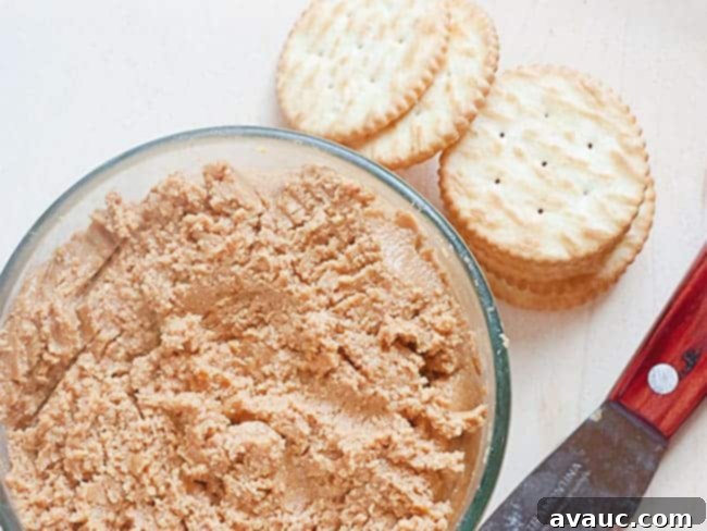 Homemade peanut butter spread on a cracker, ready to eat.