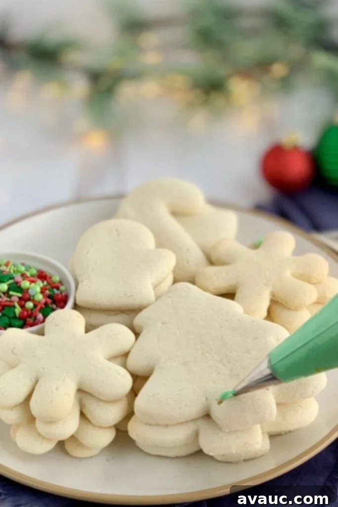 Deliciously Soft Gluten and Dairy Free Sugar Cookies 2 A piping bag about to pipe green frosting on a pile of Gluten Free Sugar Cookies.