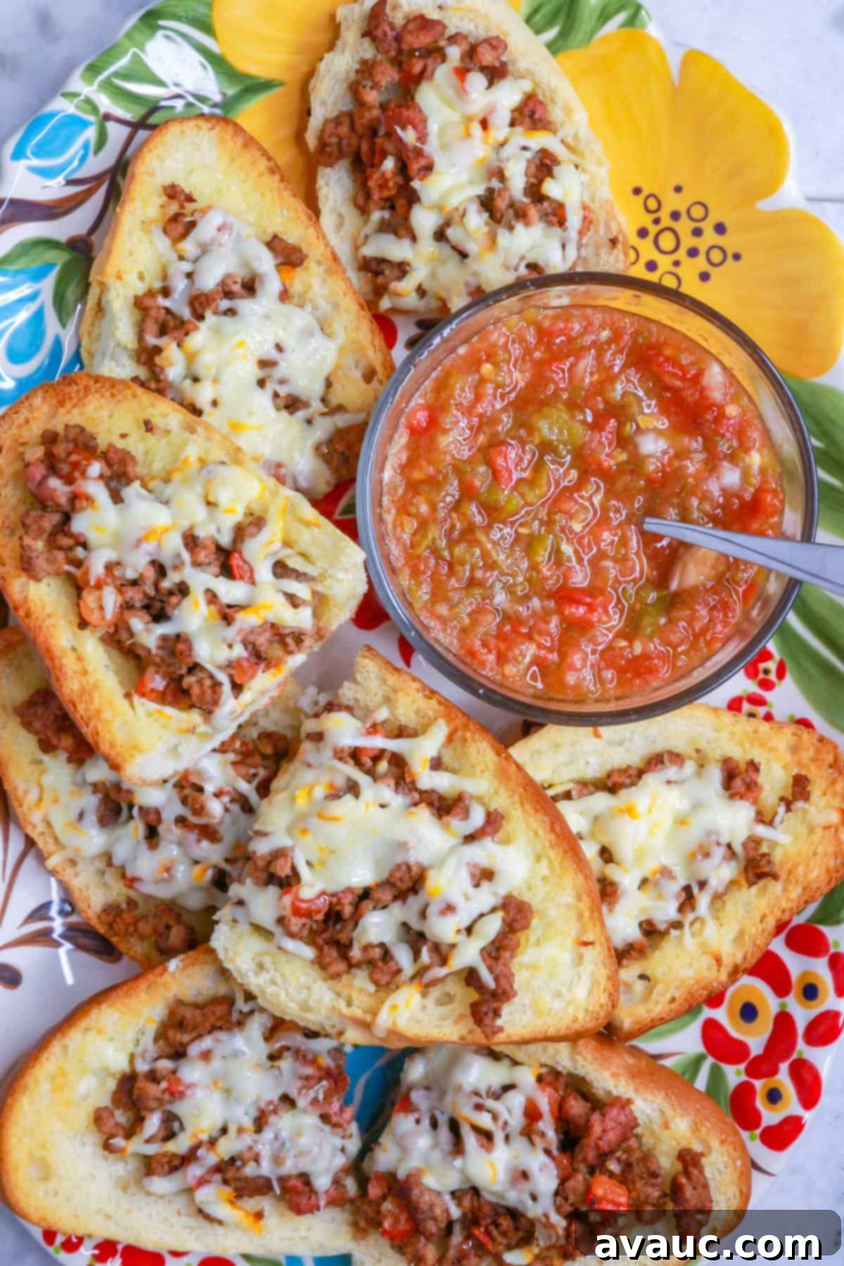 Loaded Cheesy Ground Beef Tortas 2 Top view of open-faced ground beef tortas on a platter with a bowl of fresh salsa