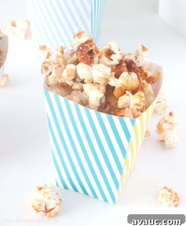 Pink, yellow, and blue striped free printable popcorn box template filled with kettle corn for birthday, circus party, baby shower.