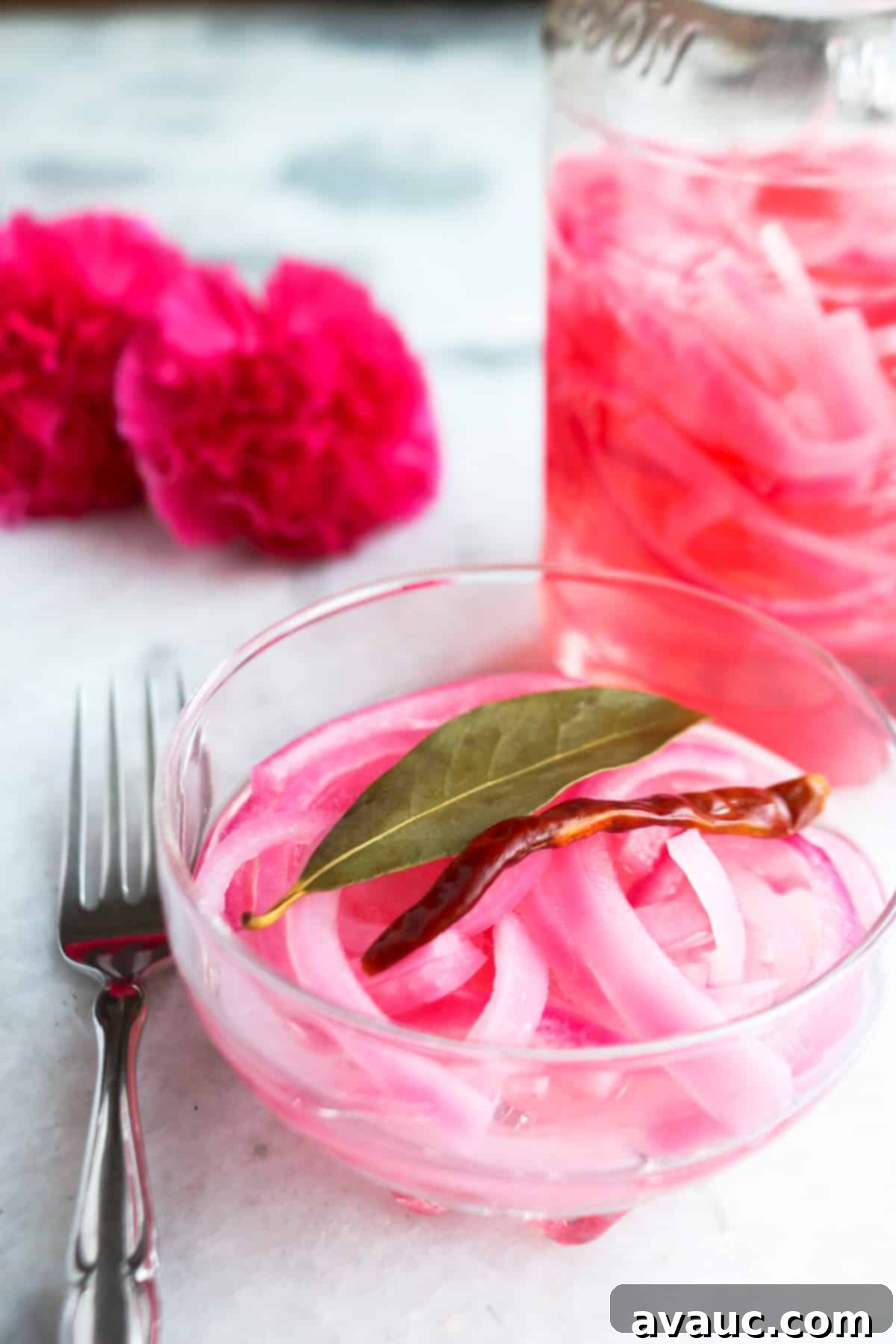 Mexican Pickled Onions 2 Bowl of Mexican pickled onions with a jar of pickled onions behind it, showcasing their vibrant color and texture.