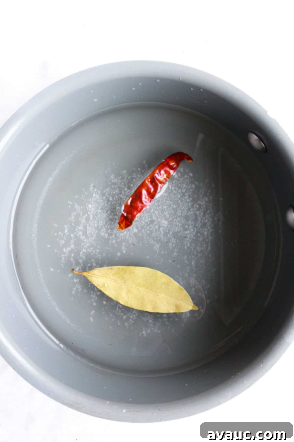 Mexican Pickled Onions 5 A small saucepan on the stove with the pickling brine ingredients: vinegar, water, sugar, salt, bay leaf, and chiles de arbol.