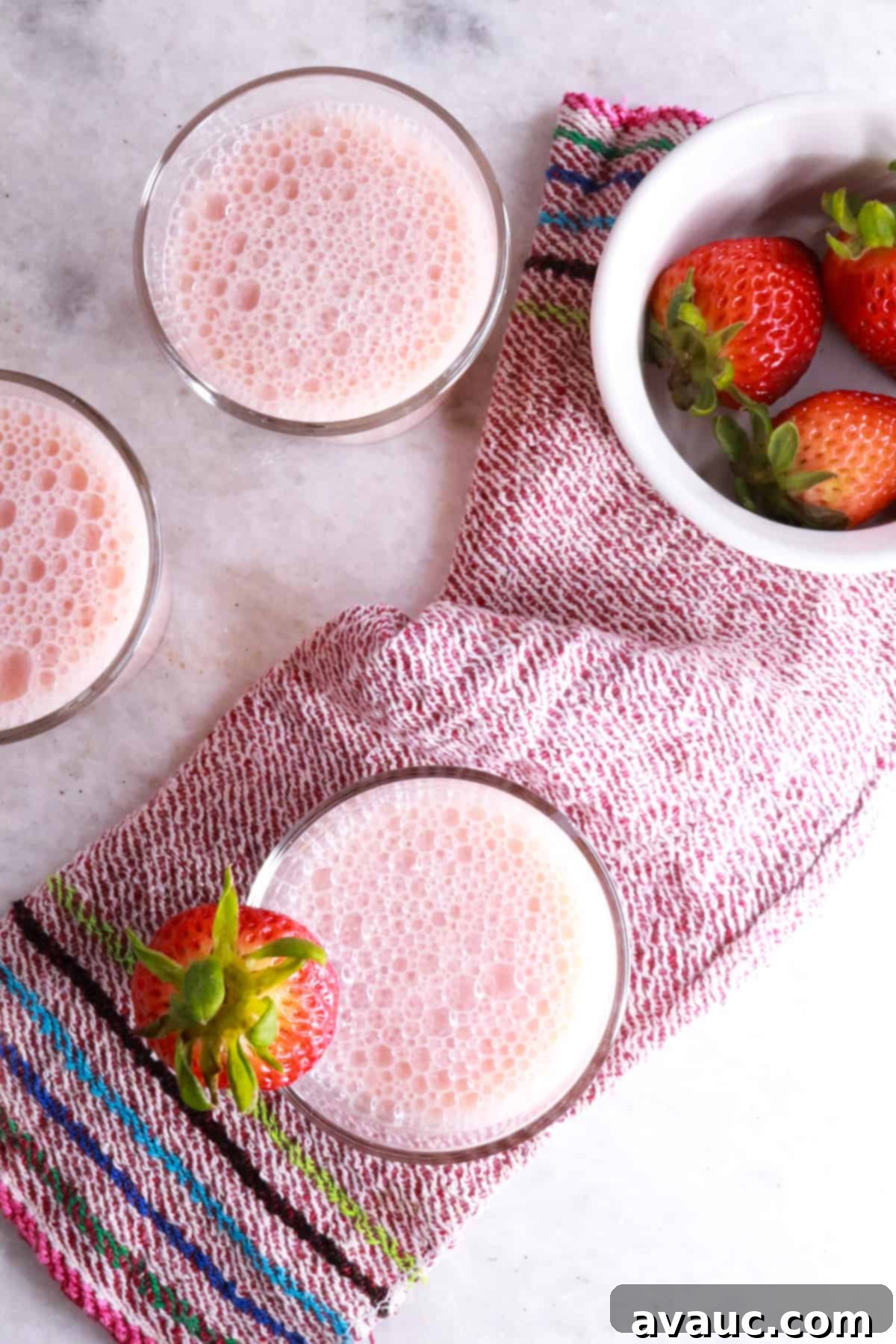 Blissful Strawberry Fresca 7 3 glasses from up above with strawberry agua fresca and a bowl of strawberries