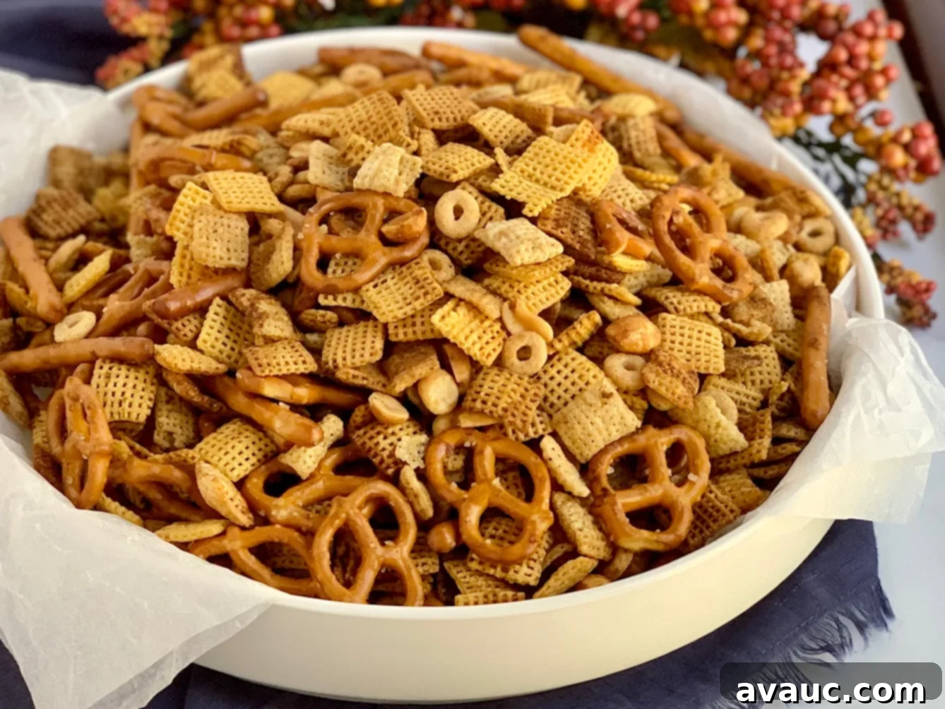 A big serving bowl of Chex Mix including pretzels, peanuts, chex cereal, and  rice chex.