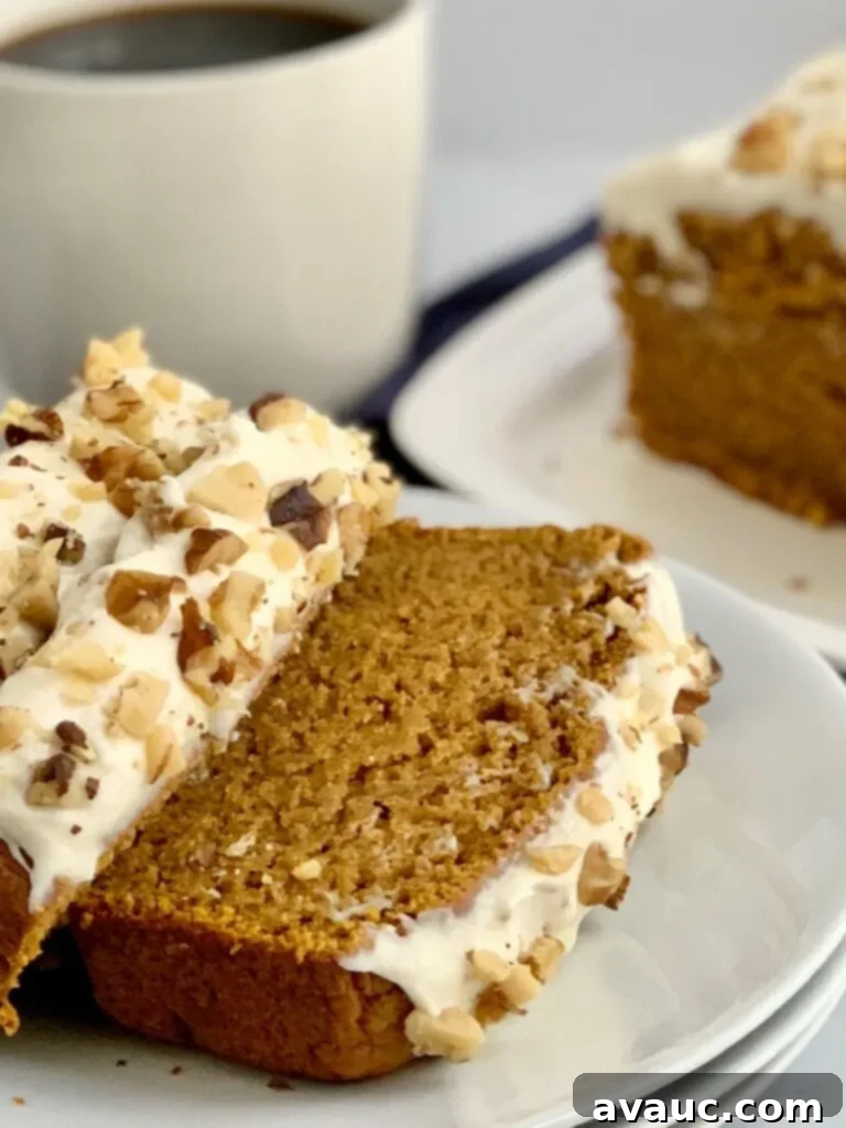 Sliced layers of pumpkin bread iced with a dairy free cream cheese frosting.