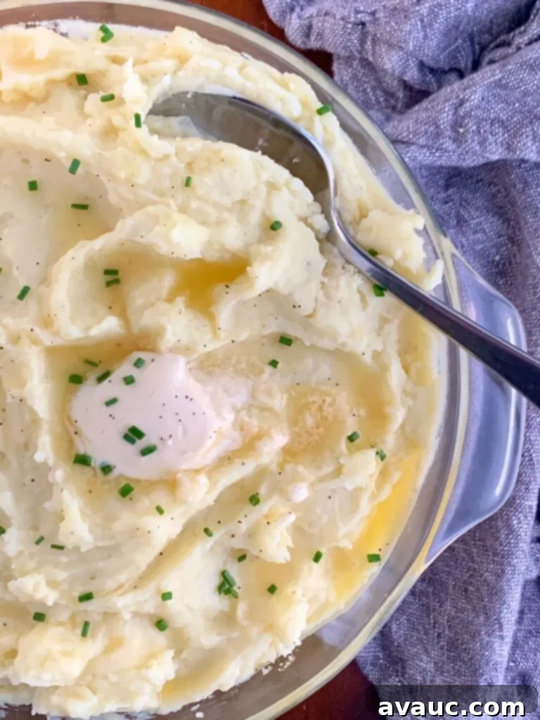 creamy mashed potatoes with melted dairy free butter on top with chopped herbs