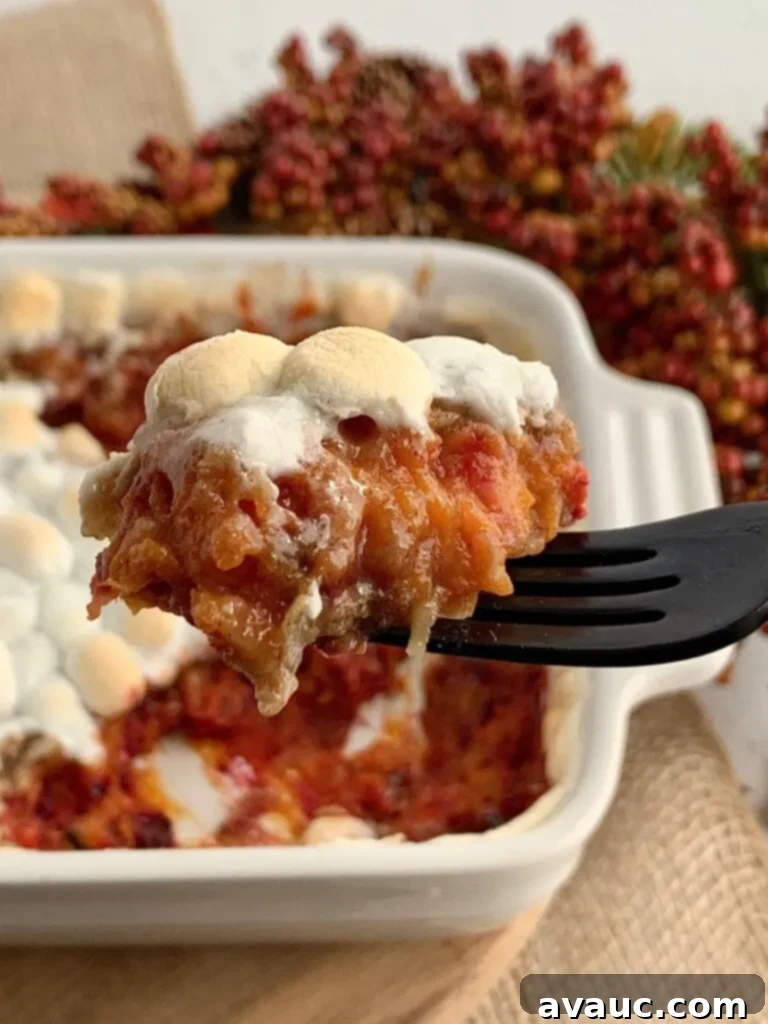 a forkful of baked sweet potato bake next to a baking pan of more mixture.