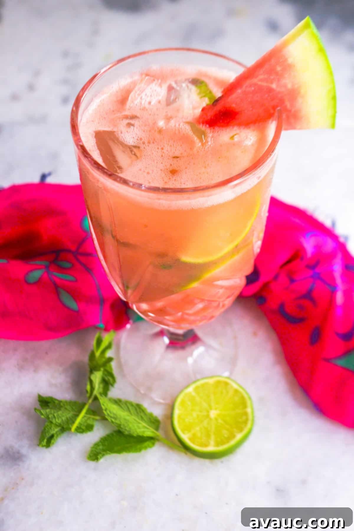 Glass with sparkling watermelon mint agua fresca and garnished with piece of watermelon