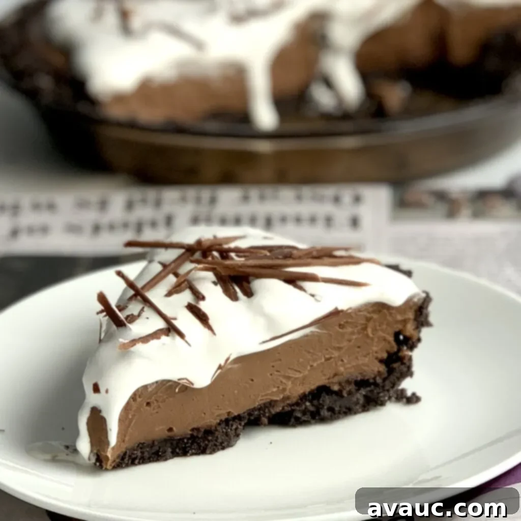 A generous slice of rich chocolate cream pie, featuring a delightful Oreo-like crust and a cloud of safe whipped topping, ready to be savored.