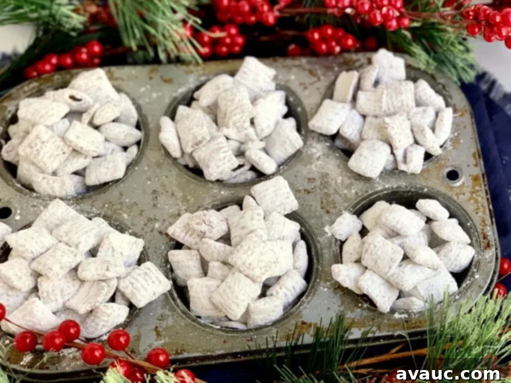 A muffin tin neatly filled with irresistible puppy chow, showcasing its chocolaty and peanut butter coated cereal dusted with powdered sugar.