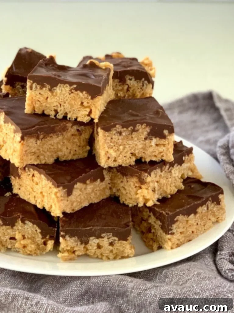A plate piled high with golden-brown Oh Henry Bars, showcasing their delicious layers of oats, peanut butter, and chocolate.
