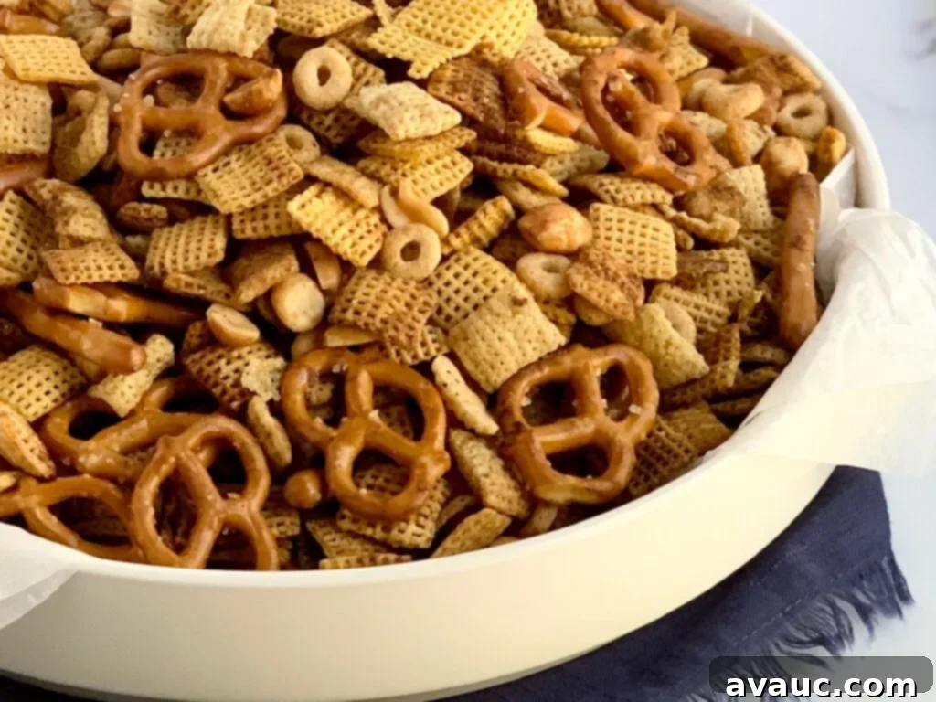 A festive serving platter generously loaded with a crunchy mix of pretzels, peanuts, crisp rice Chex cereal, corn Chex cereal, and Whole O's, perfect for holiday snacking.