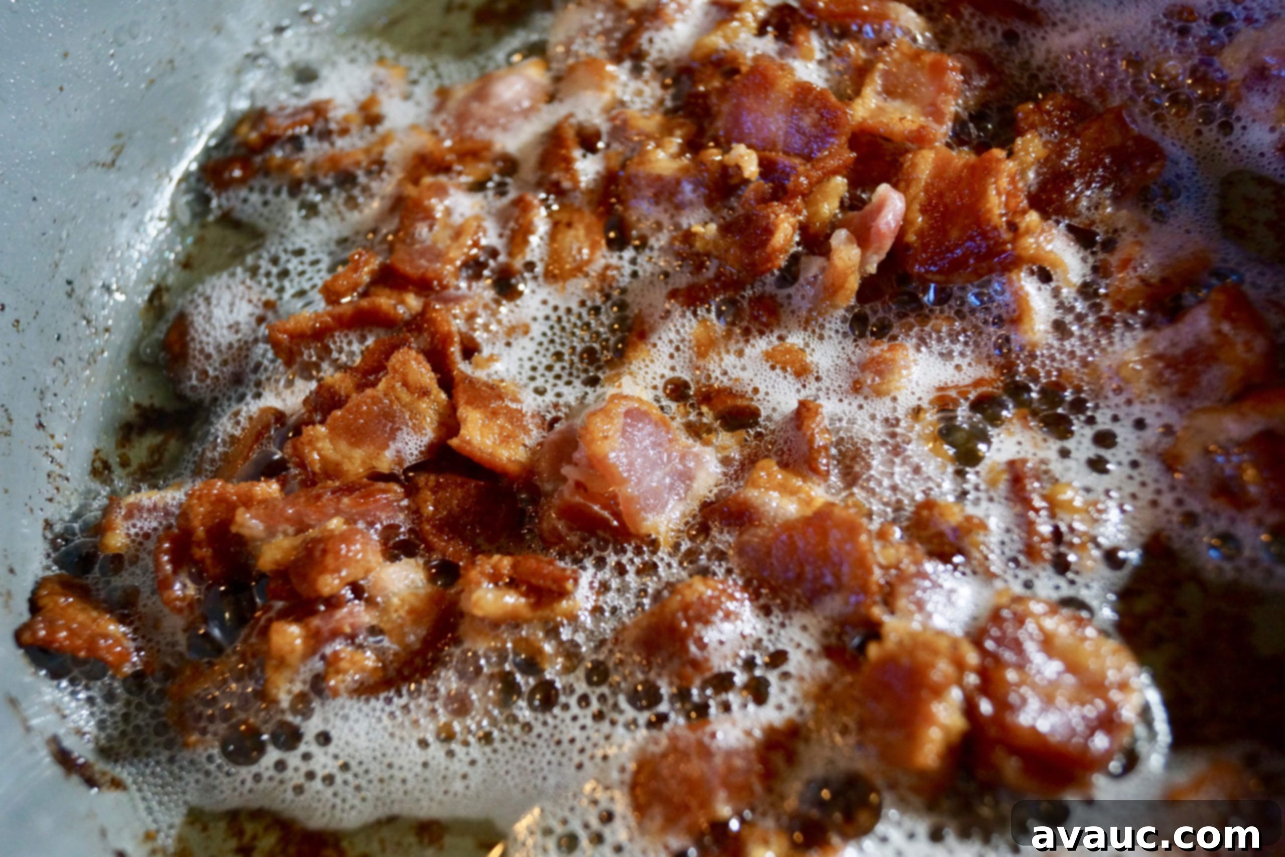 Crispy diced bacon cooked in a skillet, ready to be drained