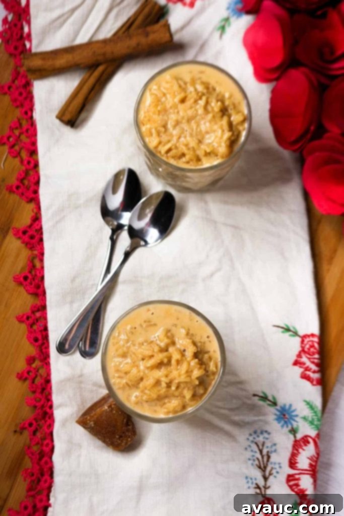 Mexican Rice Pudding 2 Birds eye view of two glasses with creamy Mexican Arroz con Leche garnished with cinnamon, alongside two spoons.