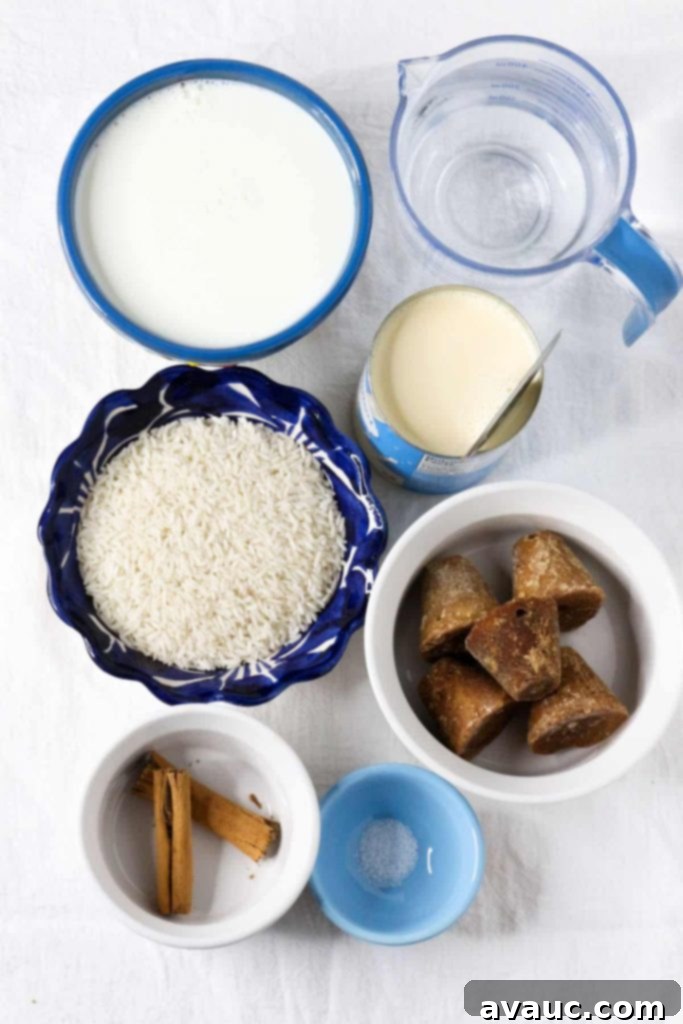 Mexican Rice Pudding 3 Bowl with whole milk, measuring cup with water, a can of evaporated milk, white long-grain rice, piloncillo cones, aromatic cinnamon sticks, and a pinch of salt on a clean white background, ready for making Arroz con Leche.