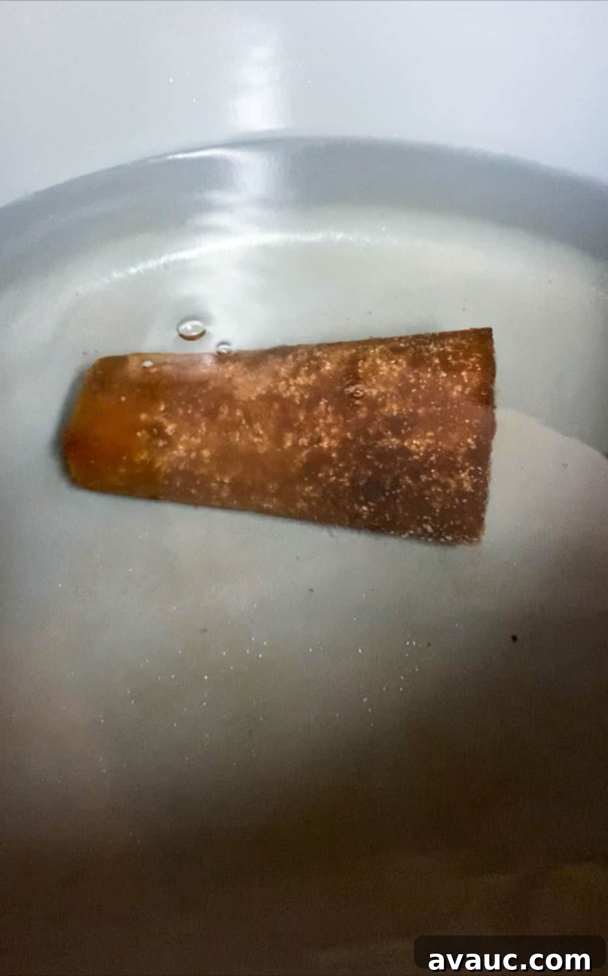 A piloncillo cone in a pot of water