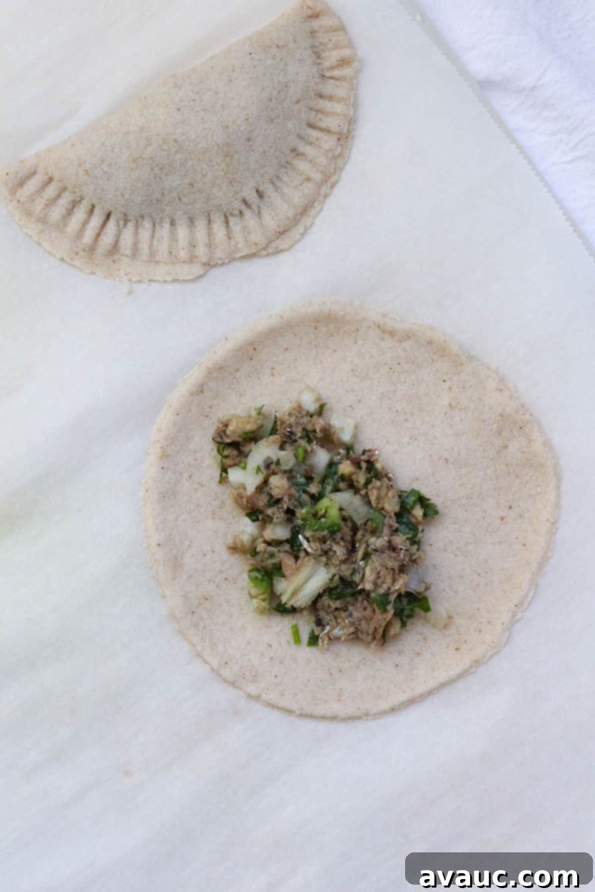 Savory Gluten-Free Sardine Empanadas 8 A gluten-free round of dough with sardine filling and an empanada waiting to be fried