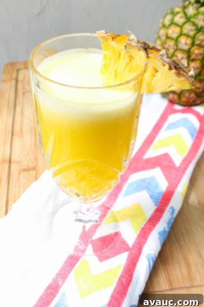 Fresh Pineapple Cooler 7 Step 4: The blended pineapple agua fresca is poured through a fine mesh sieve into a pitcher.