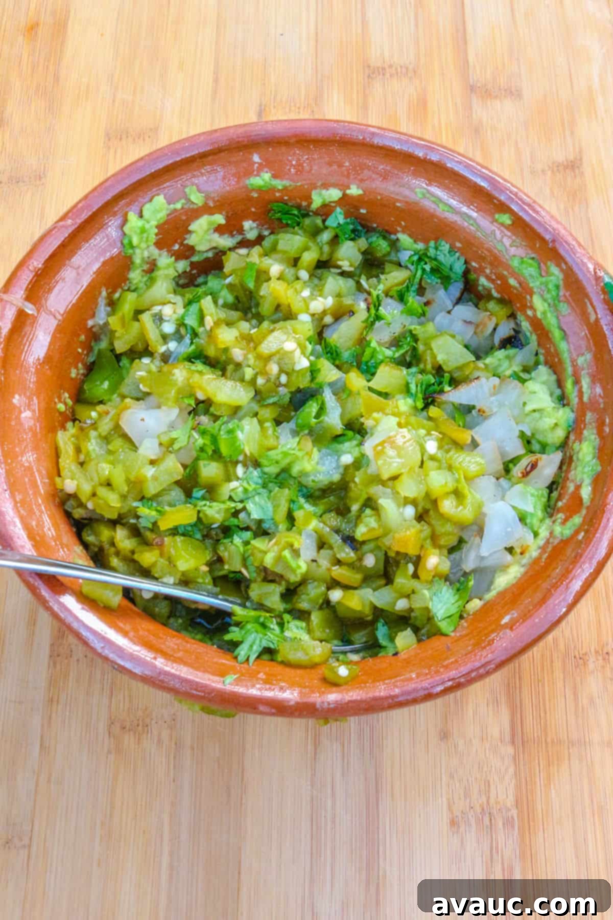 Smoky Roasted Green Chile Guacamole 7 Combining mashed avocado with diced green chiles, onion, and cilantro in a mixing bowl