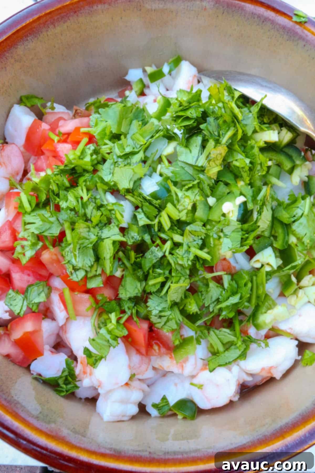 Zesty Mexican Shrimp Ceviche 6 A brown bowl with shrimp,diced tomatoes and cilantro