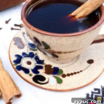 Authentic Café de Olla Recipe 8 Cafe de Olla in a pottery mug with blue flowers and a cinnamon stick