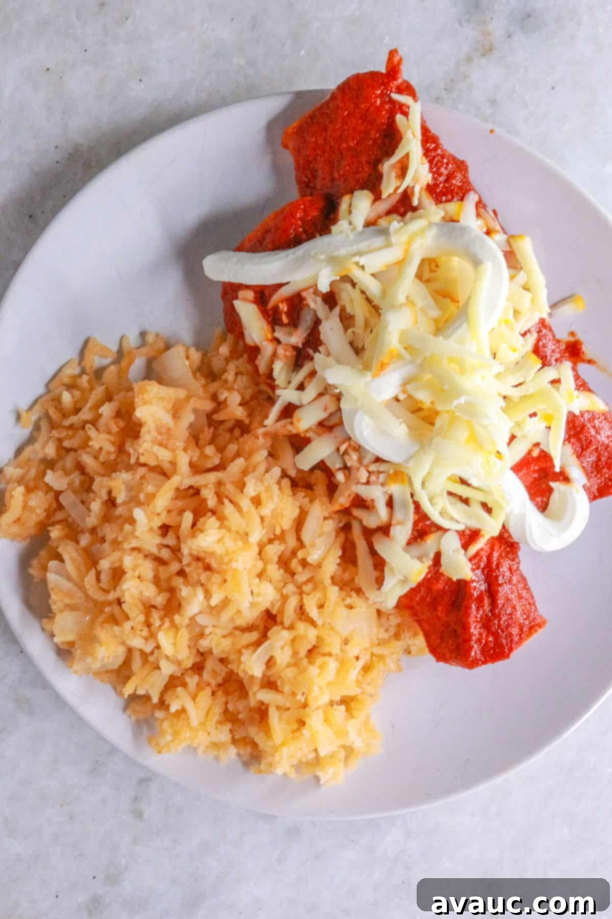 Classic Shredded Beef Enchiladas Rojas 10 Two freshly prepared Enchiladas Rojas with shredded beef on a white plate, served with a side of Mexican red rice.