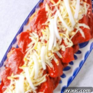 Classic Shredded Beef Enchiladas Rojas 12 Enchiladas Rojas with shredded beef on a platter, garnished with cheese and onions.