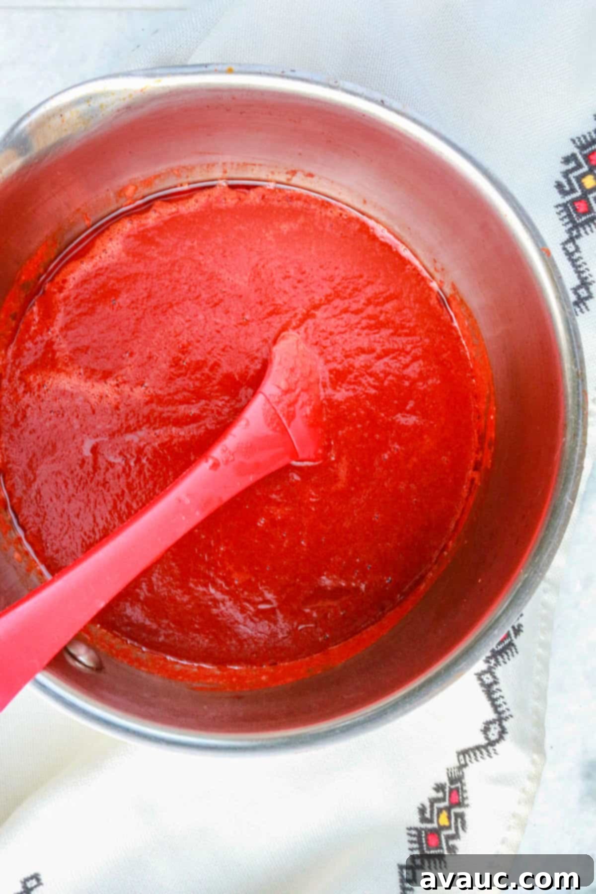 Classic Shredded Beef Enchiladas Rojas 7 Rich red guajillo enchilada sauce simmering gently in a saucepan, beginning to thicken.