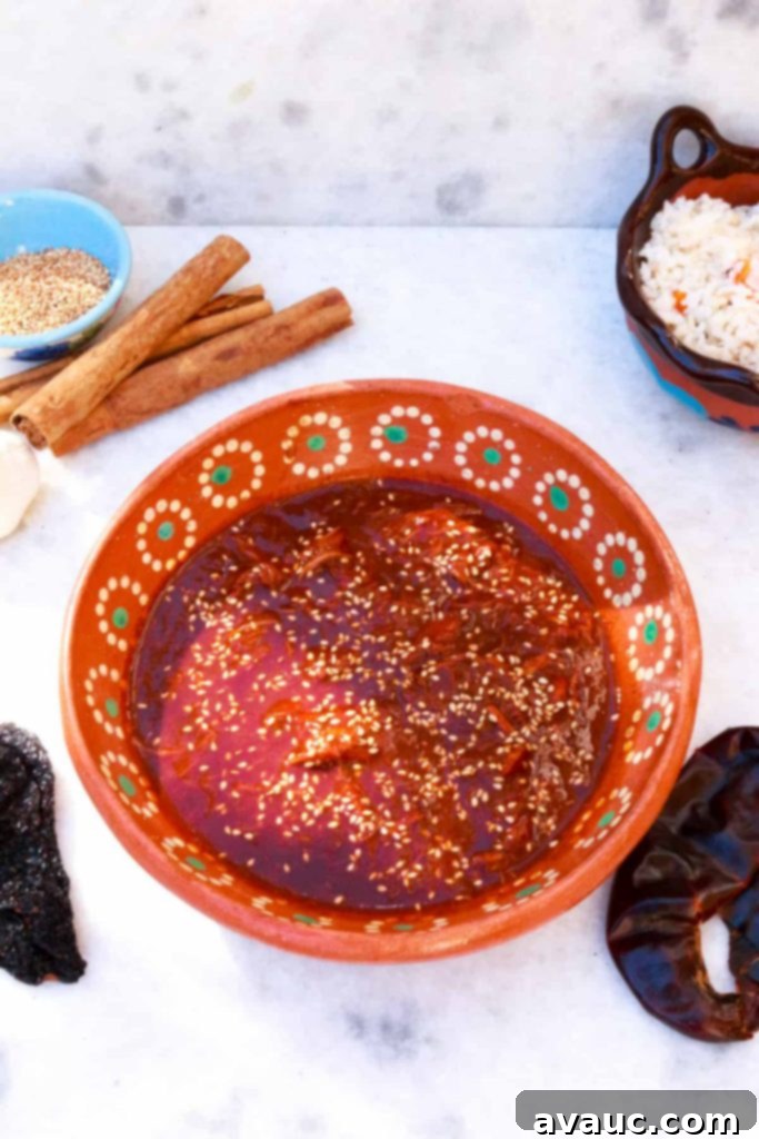 A Gluten-Free Take on Mole Poblano 8 Bowl of mole with dried chiles, cinnamon sticks, sesame seeds and garlic, and white rice in the background