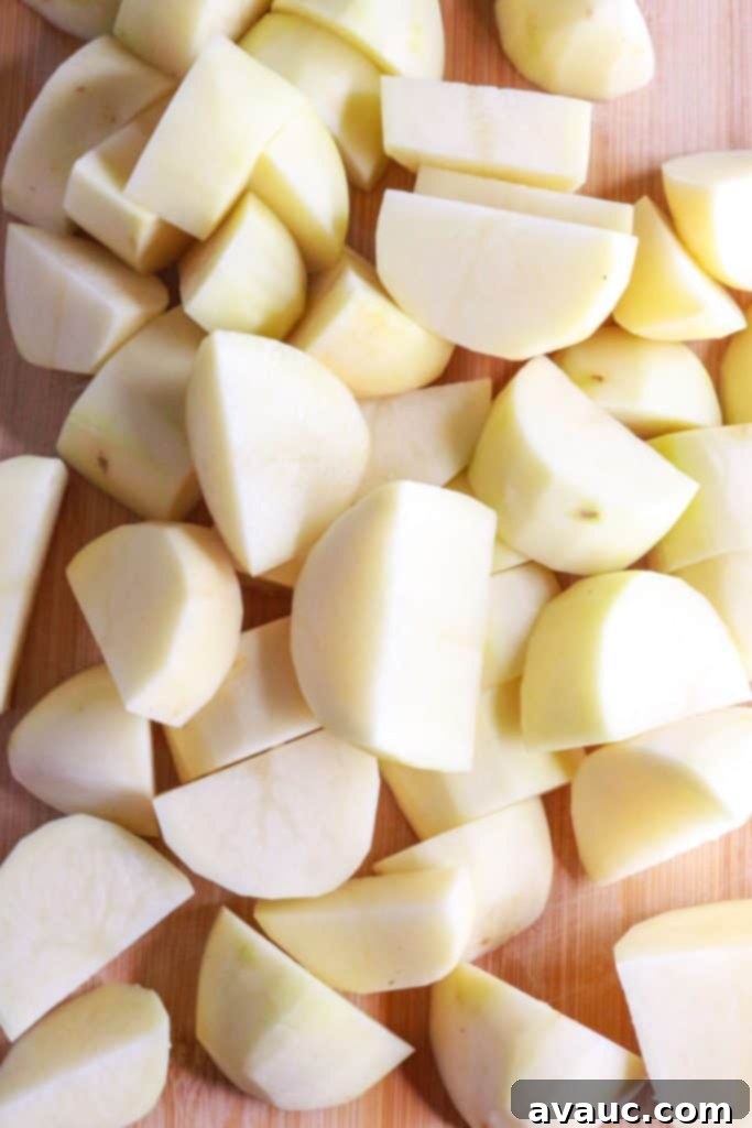 Creamy Instant Pot Garlic Mash 4 Cut up potatoes on cutting board