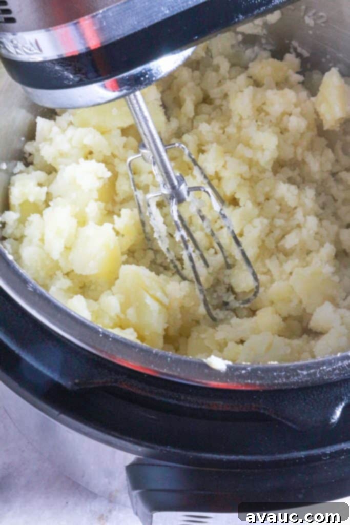 Creamy Instant Pot Garlic Mash 7 Hand mixer mixing potatoes for mashed potatoes