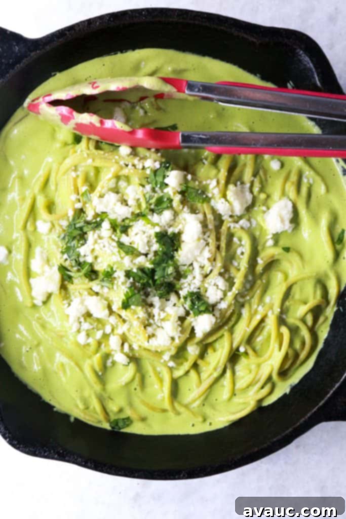 Mexican Green Spaghetti 8 Close-up shot of Espagueti Verde garnished with crumbled queso fresco and vibrant fresh cilantro, showcasing the creamy green sauce