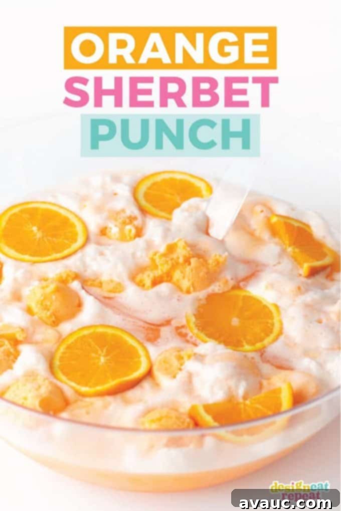 Creamy Orange Fizz 2 Orange Sherbet Punch in a large glass punch bowl with orange slices and a ladle, perfect for summer parties or Halloween.